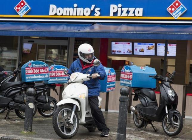 A staff member delivers take-away pizzas to customers at a Domino's Pizza store in Berlin