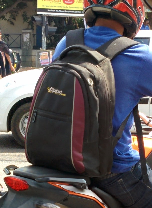 A Flipkart employee  proudly taking the company laptop bag places